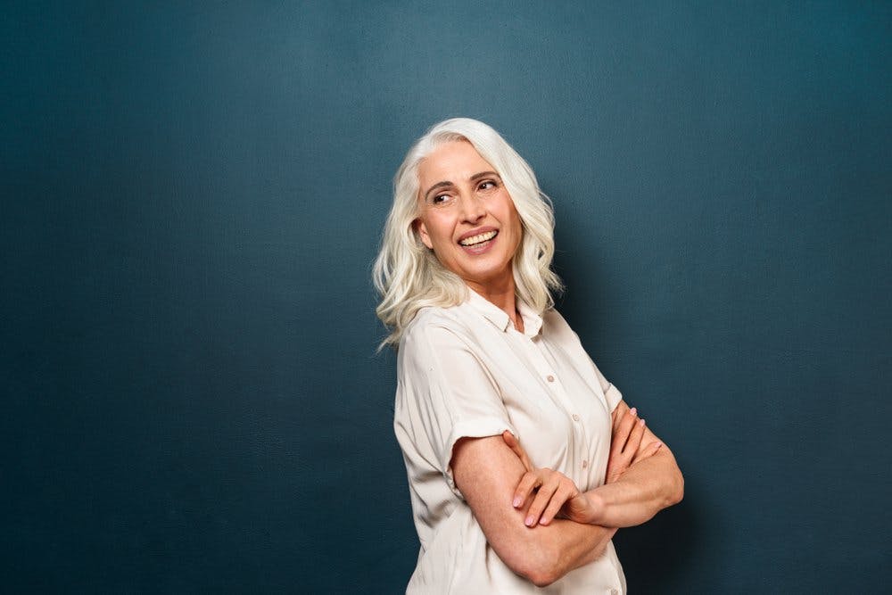 Happy white haired woman on blue background